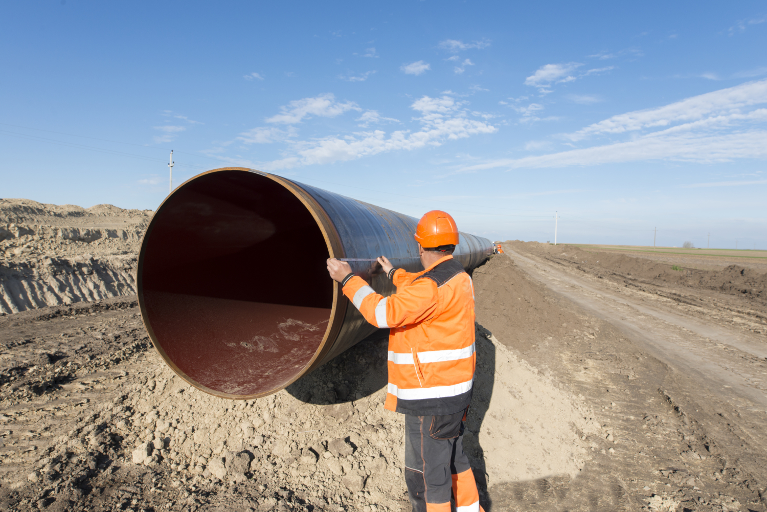 Pipeline workers measuring tube length